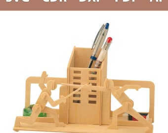 Op de afbeelding: Een bureau-organizer van lichtgekleurd hout met een centrale rechthoekige pennenhouder, geflankeerd door twee gestileerde figuren die een schermwedstrijd houden. De structuur bevat vakjes voor pennen, met de tekst SVG - CDR - DXF - PDF - AI zichtbaar.
