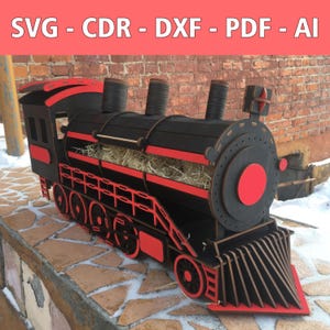 Può includere: Un treno giocattolo in legno nero e rosso con un camino e ruote rosse. Il treno ha un design a strisce rosso e nero sul lato e un cerchio rosso sul davanti. Il treno è seduto su una superficie di mattoni.