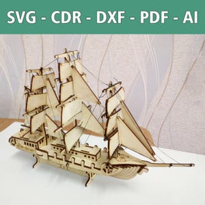 Könnte beinhalten: Ein hölzernes Schiffsmodell mit Segeln, einem detaillierten Rumpf und einem Ständer. Das Schiff ist aus hellem Holz gefertigt und hat eine natürliche Oberfläche. Die Segel sind weiß und aus dünnem Stoff gefertigt. Das Schiff ist ein klassisches Design und wäre eine großartige Ergänzung für jedes Zuhause.