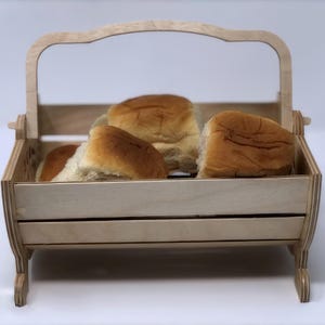 May include: A wooden bread basket with a handle, filled with four soft, golden brown rolls.