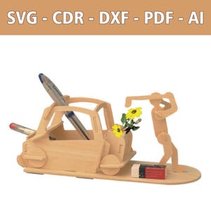 May include: A light-colored wooden desk organizer shaped like a car with a figure pushing it from behind. The structure includes slots for pens and pencils, with text at the top reading SVG - CDR - DXF - PDF - AI. A small eraser sits on the base.