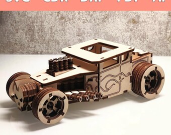 Könnte beinhalten: Ein Holzmodell eines Hot-Rod-Autos mit einem Totenkopfdesign an der Vorderseite, Flammen an der Seite und einem detaillierten Motor mit Auspuffrohren. Das Auto ist aus hellbraunem Holz gefertigt und hat ein Schwarz-Weiß-Farbschema.