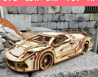 Op de afbeelding: Een houten modelbouwpakket van een slanke, lichtbruine sportwagen met een gedetailleerd interieur en een open dak. De auto staat op een bruine stenen ondergrond.
