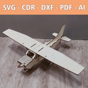 May include: A light-colored wooden model airplane with a high-wing design and a propeller. The image includes the text SVG - CDR - DXF - PDF - AI at the top, indicating available digital file formats for this laser-cut craft project.