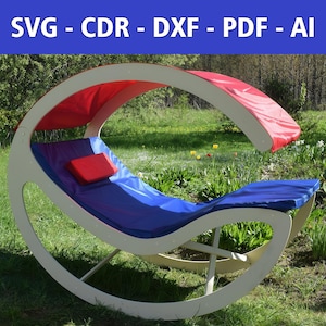 Puede incluir: Una mecedora de madera blanca con una capota y cojines rojos y azules. La silla está en un área cubierta de hierba con vegetación verde.