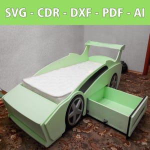 May include: A light green car-shaped bed with a black stripe and a storage drawer. The bed has a white mattress and a gray wheel with a black tire.