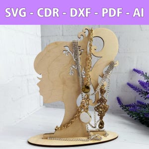 May include: Wooden silhouette of a woman's head with a decorative design, used as a jewelry stand.  The stand is holding several necklaces with gold and silver chains and pendants.