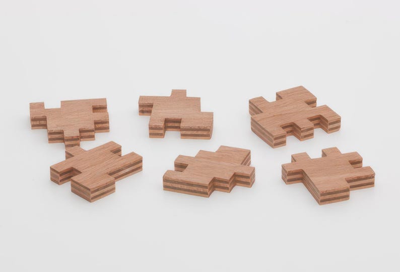 May include: Six wooden puzzle pieces, each with a different shape and layered design. The pieces are made of light brown wood and have a natural finish.