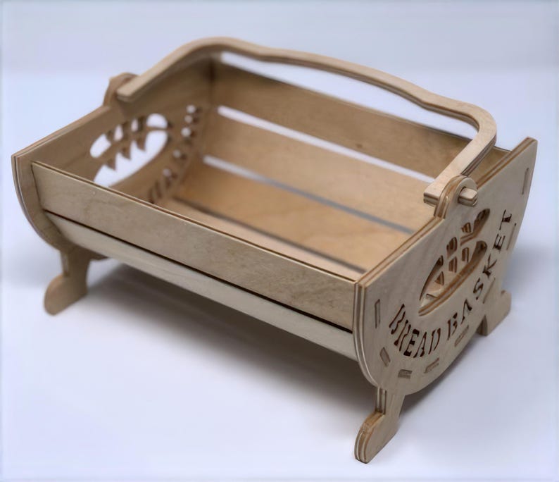 May include: A wooden bread basket with a handle and the words "Bread Basket" carved into the side.