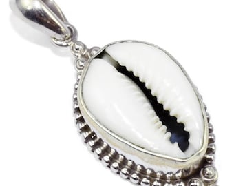 May include: A silver pendant featuring a white cowrie shell with a detailed silver border. The pendant has a silver bail for attaching to a chain.