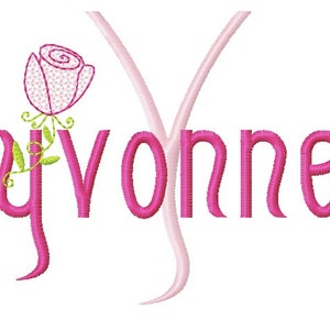 Puede incluir: Nombre "Yvonne" bordado en rosa con una rosa rosa y hojas verdes.