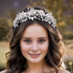 May include: A silver bridal headband with pearl and crystal embellishments. The headband is worn by a woman with long brown hair.