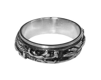 Può includere: Un anello d'argento con un designo di drago dettagliato. L'anello è in metallo e ha una finitura liscia e lucida.