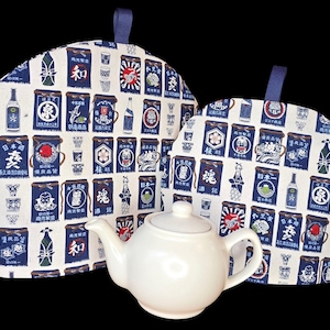 May include: Two blue and white patterned tea cozy covers with a white teapot in the center. The tea cosies are decorated with Japanese characters and images of sake bottles.