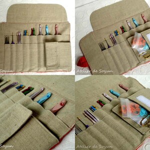 May include: Beige linen crochet hook organizer with red trim. The open case displays various crochet hooks in different colors, along with other tools. A small pocket holds accessories. The text "Atelier de Soyun" is visible.