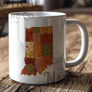 May include: White ceramic mug with a patchwork design in the shape of Indiana. The mug has a curved handle and sits on a wooden surface. The mug has the text "NAUTICAL TRADING CO." and "PREMIUM DESIGNS & QUALITY" printed on it.