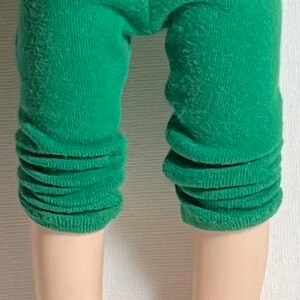 May include: Green leggings for a doll, with a cuffed bottom.