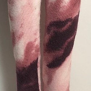 May include: Pink and brown tie-dye leggings with a white background. The leggings are made of a soft, stretchy material and have a comfortable fit. The leggings are paired with brown suede boots with laces.