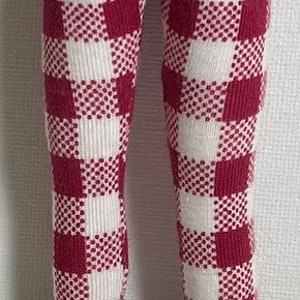 May include: Red and white checkered leggings with a brown leather boot.