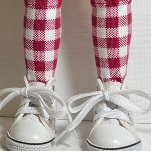 May include: White canvas high-top sneakers with red and white gingham socks.