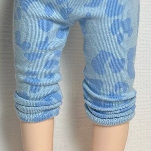 May include: Light blue leggings with a white floral pattern. The leggings are made of a soft, stretchy fabric and have a cuffed hem.