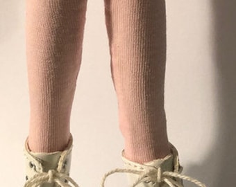May include: A pair of pink leggings with white lace-up boots. The boots have black soles.