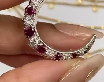 May include: A vintage 9ct London hallmarked diamond and ruby crescent ring. The ring is made of white metal and features a row of rubies and diamonds. The ring is on sale for $2400. Clearance $2400.