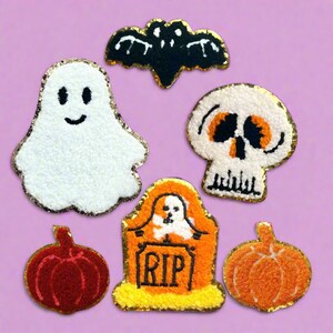 May include: A set of six Halloween-themed iron-on patches. The patches are made of fuzzy fabric and feature a ghost, a bat, a skull, a pumpkin, a pumpkin, and a tombstone with the words "RIP" on it.