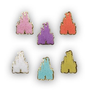 May include: Six felt castle appliques in various colors, including pink, orange, purple, white, blue, and yellow. Each applique has a gold outline.