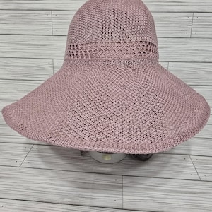 May include: A wide-brimmed, pink knitted sun hat with a mesh panel around the crown.