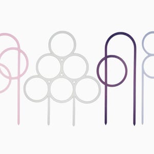 May include: Four different metal plant stakes with circular designs. The stakes are in pink, white, purple, and light blue.