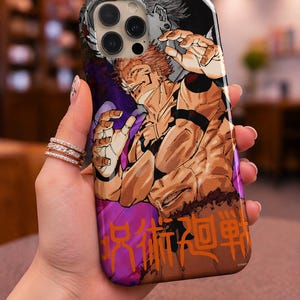 Op de afbeelding: Telefoonhoesje met een levendige illustratie in anime-stijl. Het ontwerp toont een gespierd personage met oranje haar in een dynamische pose, tegen een paarse en oranje achtergrond. Japanse tekst is zichtbaar aan de onderkant.