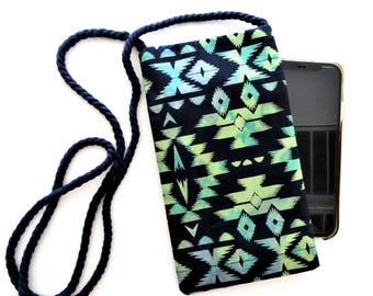 May include: A black and teal patterned phone crossbody bag with a navy blue rope strap. The fabric design features geometric shapes in teal and green against a black background. A smartphone is partially visible inside the bag.