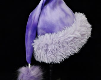 Gorro de Papá Noel de felpa con estampado tie-dye morado y ribete de piel sintética.