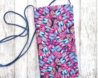 May include: A rectangular fabric pouch featuring a vibrant pattern of overlapping pink, magenta, and light blue petal-like shapes with black dotted accents. The pouch includes a thin, dark blue cord strap attached to the top for carrying.