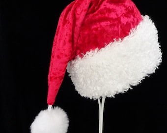 May include: A red velvet Santa hat with a white faux fur trim and a white pom-pom.