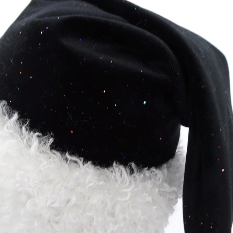 May include: A black Santa hat with a white, fluffy trim. The hat is sprinkled with colorful glitter. The hat is made of a soft fabric and has a long, pointed shape.