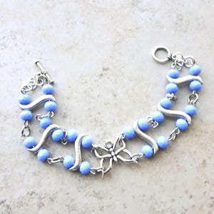 Pulsera con dije de mariposa: cuentas de vidrio azul aciano con detalles plateados