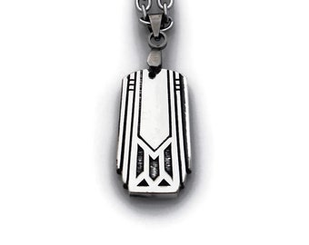 May include: A silver necklace with a geometric pendant. The pendant is a rectangular shape with an intricate design.