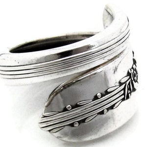 May include: A silver spoon ring with a floral design. The ring is made from a recycled spoon and is adjustable.