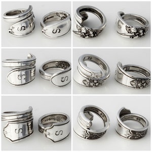May include: A set of nine silver rings made from vintage silverware. Each ring is unique and features a different design, including floral patterns and engraved letters. The rings are perfect for adding a touch of vintage charm to any outfit.
