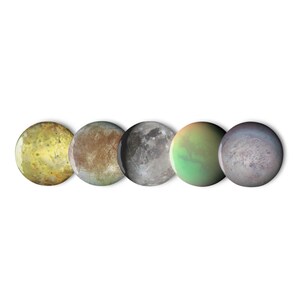 May include: A set of five circular buttons featuring detailed photographic prints of celestial bodies. The designs include a yellow mottled sphere, a brown textured surface, a grey cratered moon, a green and orange orb, and a purple-hued planet.