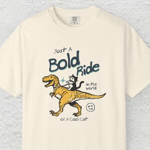 Funny Cat Riding Dinosaur T-Shirt, Retro Cat and T-Rex Graphic Tee, Quirky T-Shirt for Animal Lovers