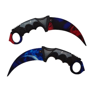 May include: Two black karambit knives with a blue and red flame design. The knives have a ring handle and the text "COUNTER STRIKE" on the blade.