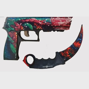 Könnte beinhalten: Dekoratives Pistolen- und Karambit-Messerset. Die Pistole und das Messer weisen ein farbenfrohes Blumendesign mit roten, grünen und blauen Farbtönen auf. Auf dem Messer steht "COUNTER STRIKE".