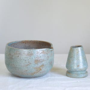 Matcha set with matte teal bowl styled with floral details and bamboo mat. Ideal for those who seek intentional rituals and love surrounding themselves with handmade pieces and calm textures.