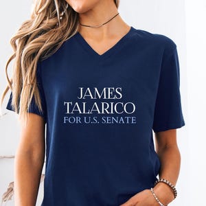 May include: Navy blue V-neck t-shirt with the text "JAMES TALARICO FOR U.S. SENATE" in white. The shirt is made of a soft material.