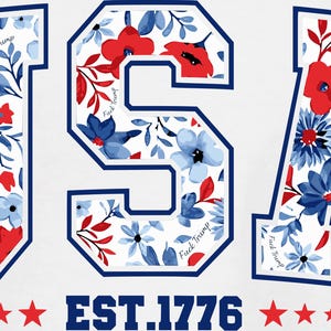 May include: White graphic design featuring the word "USA" in a varsity-style font, filled with red and blue floral patterns. The text "EST.1776" is below, with red stars. The words "Fuck Trump" are written on the letters.