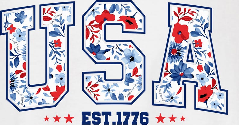 May include: White graphic design featuring the word "USA" in a varsity-style font, filled with red and blue floral patterns. The text "EST.1776" is below, with red stars. The words "Fuck Trump" are written on the letters.