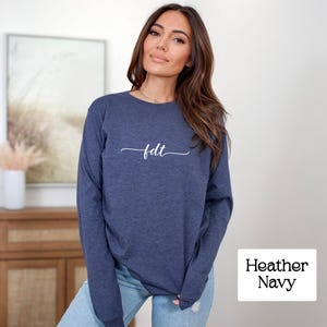 May include: A long-sleeved heather navy blue shirt with the text "fdt" in white cursive script.